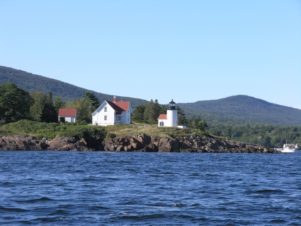 A view of Curtis Island Lighthouse from a sailboat in the bay